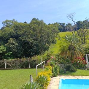 Elle offre une vue sur un jardin doté d'une piscine. dans l'établissement Chácara Sonho Meu, à Pinhalzinho