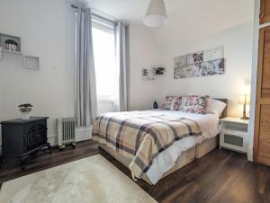 a bedroom with a bed and a fireplace and a window at Whitchurch 1 Bedroom Apartment in Cardiff