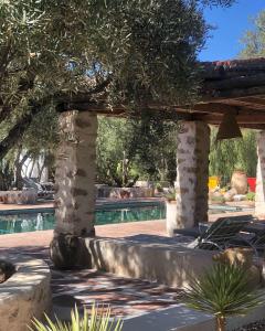 a pool with chairs and trees in a yard at Sel d Ailleurs, Atlas Mountain Retreat - adults only in Ouirgane