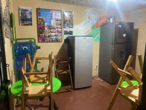 a kitchen with chairs and a refrigerator in a room at Casa de los colores San cris in San Cristóbal de Las Casas