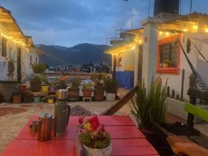 a patio with a table and potted plants and lights at Casa de los colores San cris in San Cristóbal de Las Casas
