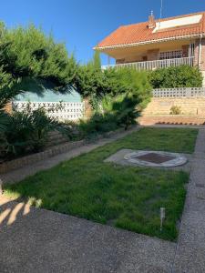 a backyard with a yard with grass and a house at casa Salou individual in Salou