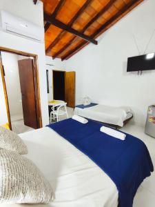 una habitación de hotel con dos camas y una mesa en Las Salinas Hostal, en Luque