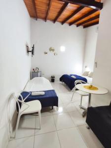 een ziekenhuiskamer met een bed en een tafel en stoelen bij Las Salinas Hostal in Luque