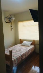 a bedroom with a bed with a fan and a window at Hospedaje La Posada del Chino in Los Órganos