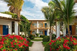 une villa avec des palmiers et des fleurs rouges dans l'établissement Hotel Paracas, a Luxury Collection Resort, Paracas, à Paracas