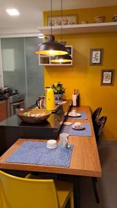uma cozinha com uma mesa de madeira e cadeiras amarelas em Cantinho familiar-Humaitá - somente mulheres - just women no Rio de Janeiro