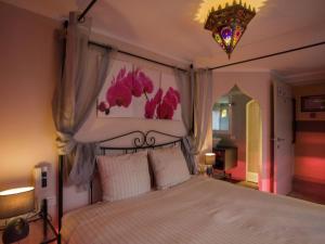 1 dormitorio con 1 cama blanca grande con dosel en Very nice manor house in North African atmosphere en Kortrijk