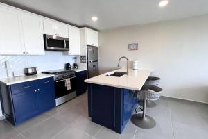 a kitchen with blue cabinets and a sink and a stove at Luxury 2BR Condo (F) Rosarito in Rosarito