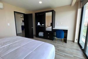a bedroom with a bed and a desk and a blue chair at Luxury 2BR Condo (F) Rosarito in Rosarito