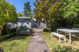 a house with a picnic table and benches in the yard at Swanbrook in Mount Victoria