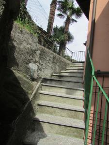 a set of stairs next to a building with palm trees at Casa Sott Al Sass in Ascona