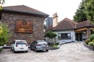 dos coches estacionados frente a un edificio en Pousada Villa Verde, en Canela