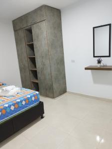 1 dormitorio con 1 cama y armario de madera en Apartamento con ubicación estratégica en Cartagena de Indias