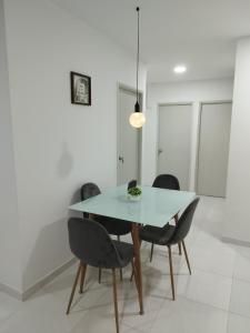 comedor con mesa blanca y sillas negras en Apartamento con ubicación estratégica en Cartagena de Indias