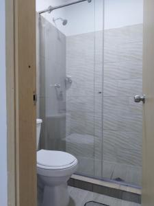 y baño con aseo y ducha acristalada. en Apartamento con ubicación estratégica en Cartagena de Indias
