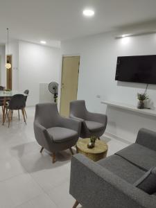 a living room with a couch and chairs and a tv at Apartamento con ubicación estratégica in Cartagena de Indias