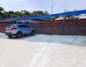 un coche aparcado en un estacionamiento con un dosel azul en Las Salinas Hostal, en Luque