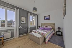 een slaapkamer met een bed, een stoel en een raam bij Cottage in Plouarzel in Plouarzel