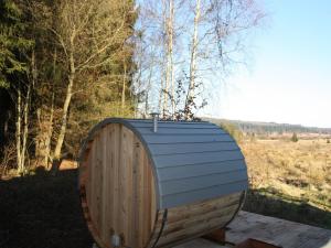 a wooden barrel sitting on a table in a field at Rustic Chalet ultimate relaxation in the forest in Sourbrodt