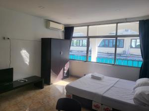 een slaapkamer met een bed en een groot raam bij THE NEST in Pattaya