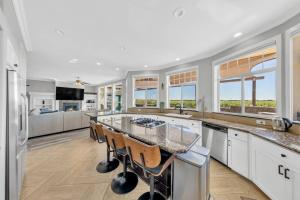 a kitchen with white cabinets and a large island at Luxe & Comfy Vineyard Estate ~ Breathtaking Views! 