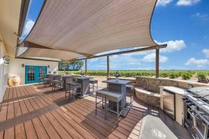 a deck with tables and chairs and a grill at Luxe & Comfy Vineyard Estate ~ Breathtaking Views! 