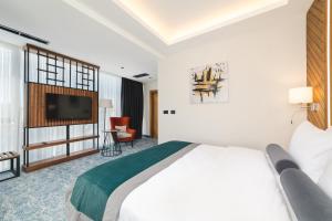 a hotel room with a bed and a flat screen tv at Bristol Hotel Podgorica in Podgorica