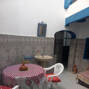 a bathroom with a table and a sink in a room at DAR TAZROUT in Tangier