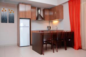 a kitchen with wooden cabinets and a counter with a refrigerator at Tsokas Hotel in Finikounta