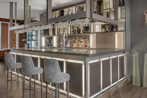 a bar with stools in a room at AC Hotel Valencia by Marriott in Valencia