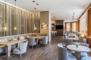 un restaurante con mesas y sillas y un bar en AC Hotel Valencia by Marriott, en Valencia