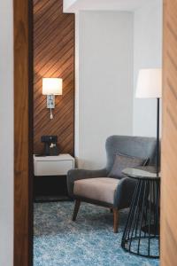 a living room with a chair and a lamp at Bristol Hotel Podgorica in Podgorica
