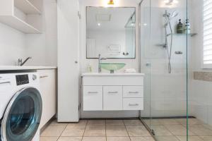 a bathroom with a washing machine and a shower at Tranquil apartment in the city in Newcastle