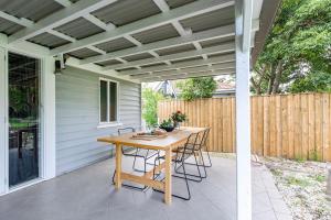 a patio with a wooden table and chairs at Nowra Beauty in Nowra