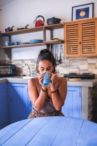 Eine Frau, die am Tisch sitzt und eine Tasse Kaffee trinkt. in der Unterkunft Hotel Casa Pino, Tu Casa en Ataco in Concepción de Ataco