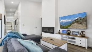 ein Wohnzimmer mit einem Sofa und einem Flachbild-TV in der Unterkunft Villa Marina in Lakes Entrance