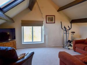 a living room with a couch and a tv and a window at Primrose Villa in Rosedale Abbey