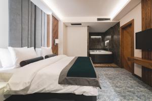 a hotel room with a large bed and a bathroom at Bristol Hotel Podgorica in Podgorica