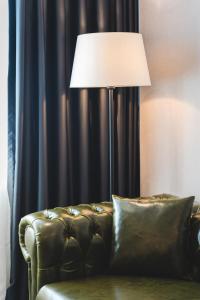 a lamp sitting next to a couch in a room at Bristol Hotel Podgorica in Podgorica