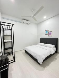 Habitación blanca con cama y espejo en K.U Homestay, en Kota Bharu