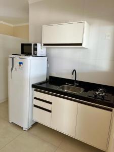 uma cozinha com um lavatório e um frigorífico branco em KITNET 1001 Apart Hotel em Piracicaba