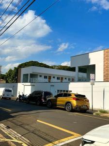 a parking lot with cars parked in front of a building at KITNET 1001 Apart Hotel in Piracicaba