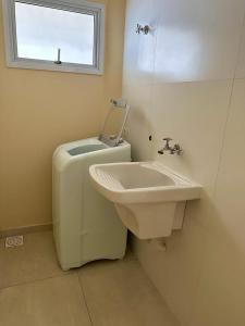 La salle de bains est pourvue d'un lavabo, de toilettes et d'une fenêtre. dans l'établissement KITNET 1001 Apart Hotel, à Piracicaba
