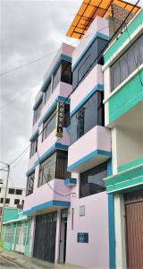 un edificio colorido al lado de una calle en Hostal Los Pinos, en Huancayo