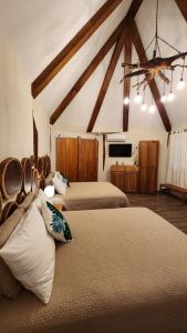 a bedroom with two beds and a tv in it at Hotel Cabañas Aldea Maya in Xpujil