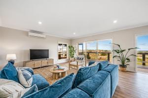 een woonkamer met een blauwe bank en een tv bij Surfers Reserve Beachfront - WIFI- Family friendly in Middleton