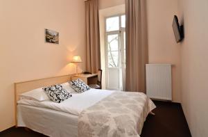 ein Schlafzimmer mit einem Bett und einem Fenster in der Unterkunft Ivolita Vilnius in Vilnius