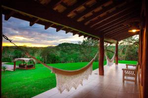 a porch with two hammocks and a green yard at Pousada Boyrá in Bonito