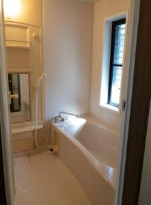 La salle de bains est pourvue d'une baignoire et d'une fenêtre. dans l'établissement Guest House Kiyohime, à Tanabe